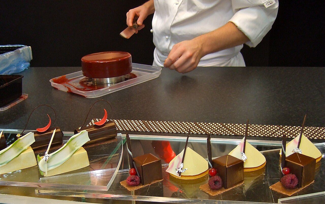 Hände richten Torten und Desserts an
