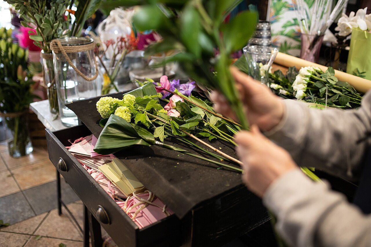 Hände binden einen Blumenstrauß