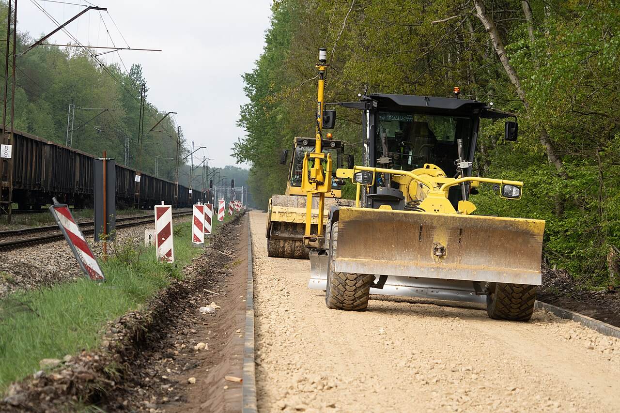 Planierraupe beim Bau eines Weges neben Gleisen