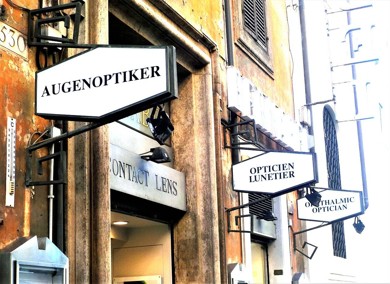 Hinweisschilder eines Augenoptikers an einer Hauswand