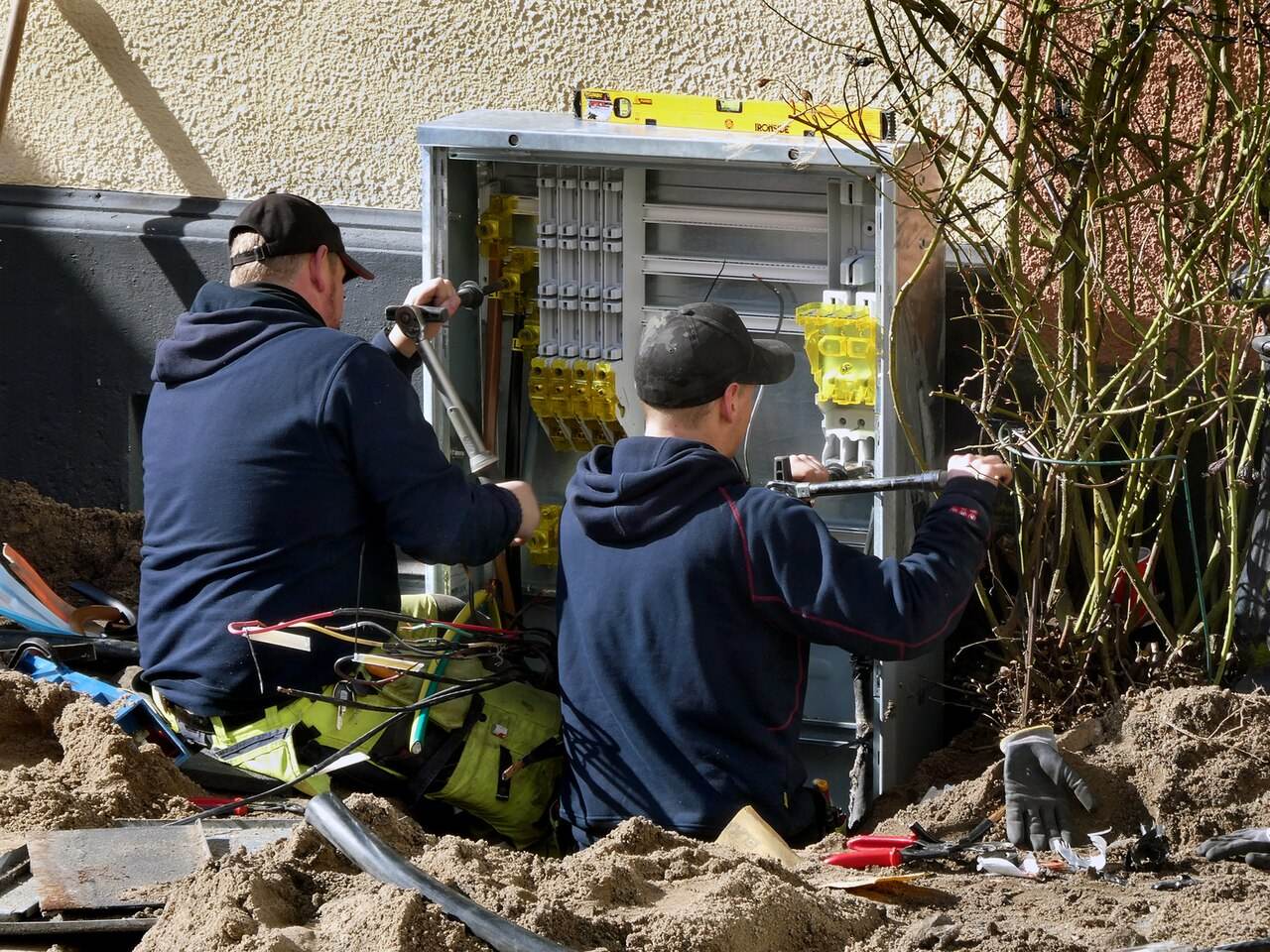 Zwei Elektriker arbeiten an einem Verteilerschrank