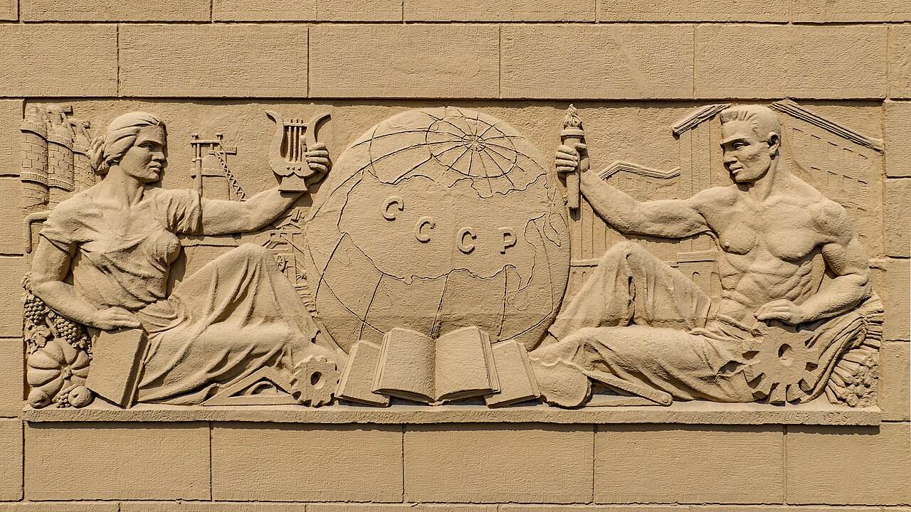 Steinrelief an einer Hauswand mit Figuren
