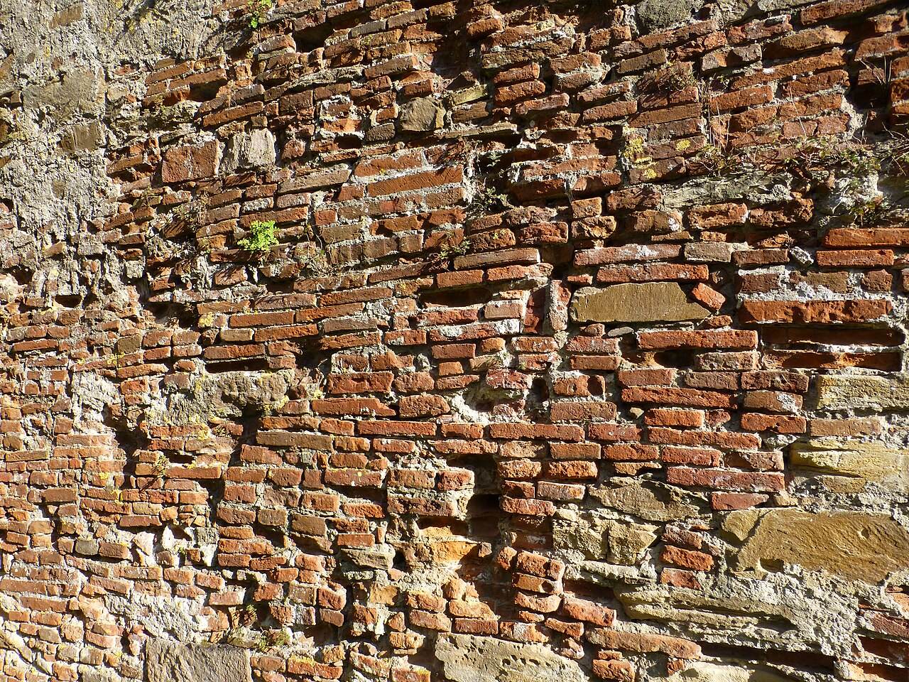 Alte Backsteinmauer mit Natursteinen