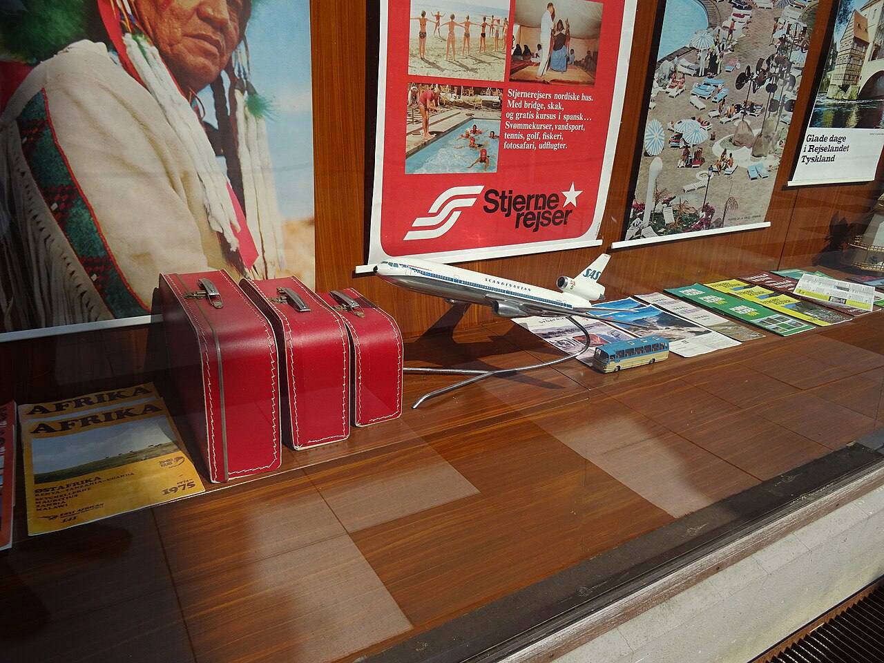Schaufenster mit Reiseprospekten, Koffern und Flugzeugmodell