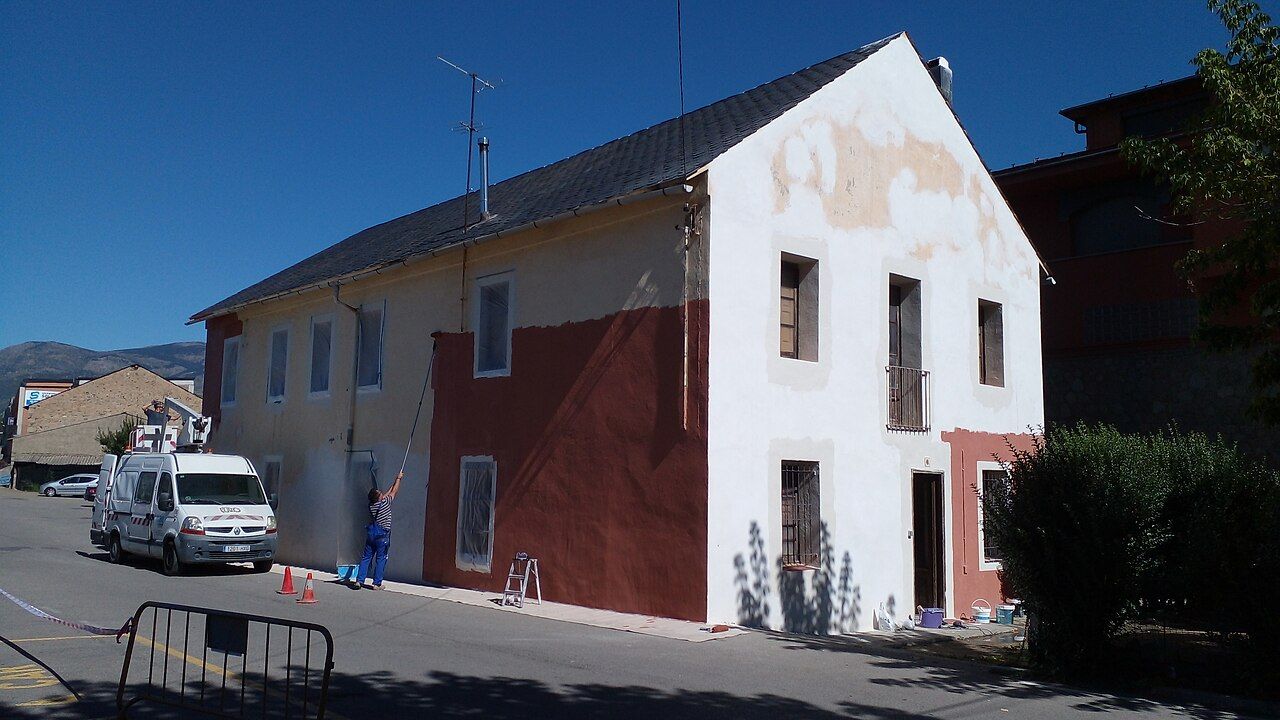 Maler streicht die Fassade eines Hauses