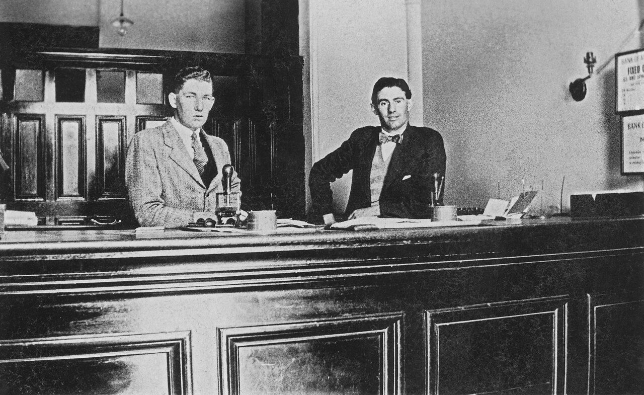 Zwei Bankangestellte hinter dem Schalter, historische Aufnahme