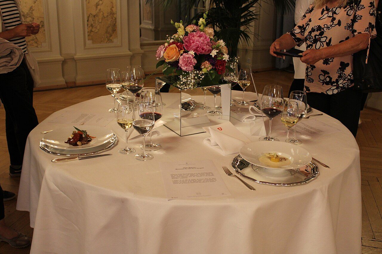 Festlich gedeckter runder Tisch mit Blumenschmuck