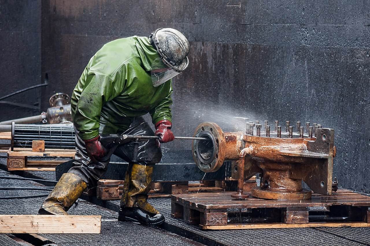 Reiniger in Schutzkleidung bei der Hochdruckreinigung