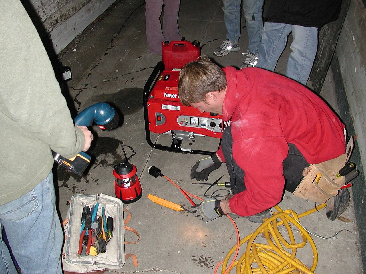 Elektriker arbeitet mit Werkzeug und Stromaggregat