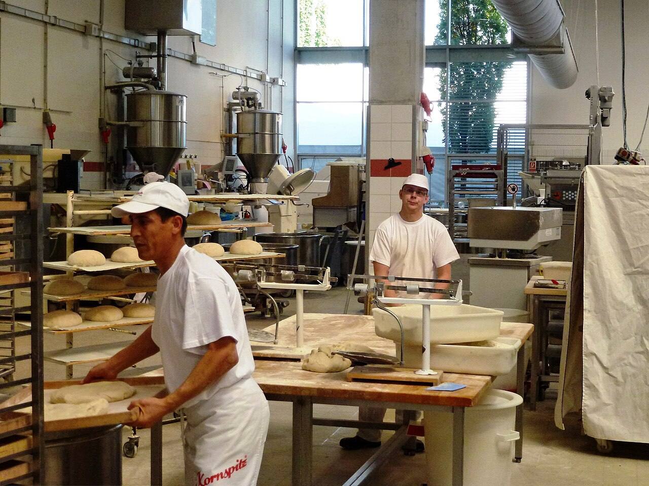 Backstube mit Bäckern an Arbeitstischen