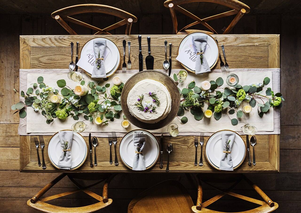 Eingedeckte Festtafel mit Tellern und Blumendekoration