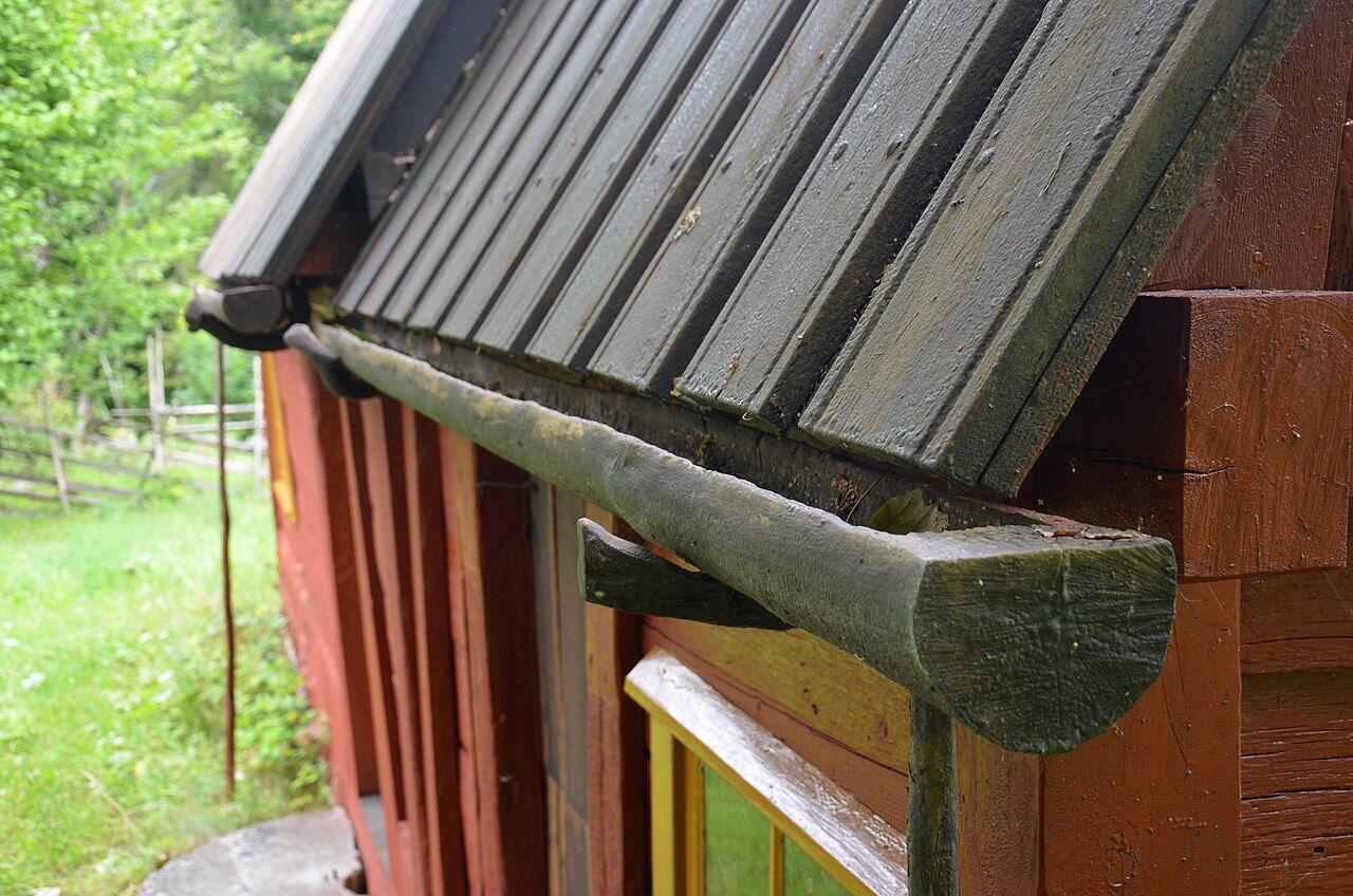 Metalldachrinne an einem Holzhaus