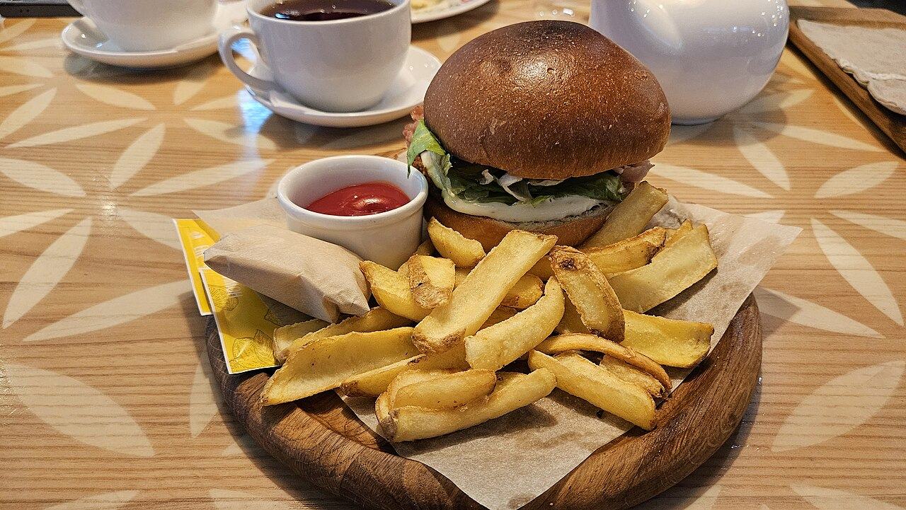Burger mit Pommes frites auf einem Holzbrett
