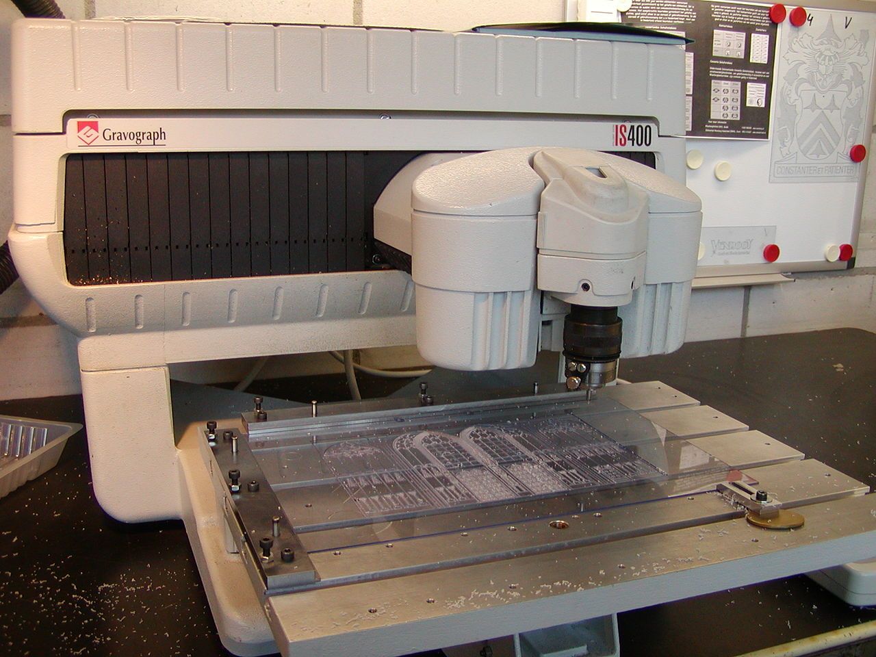 Graviermaschine mit Fräskopf über einer Platte