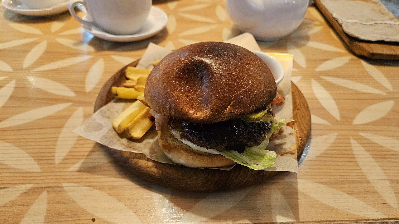 Burger mit Pommes frites auf einem Holzbrett