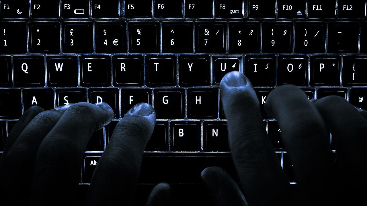 Hände auf einer beleuchteten Tastatur