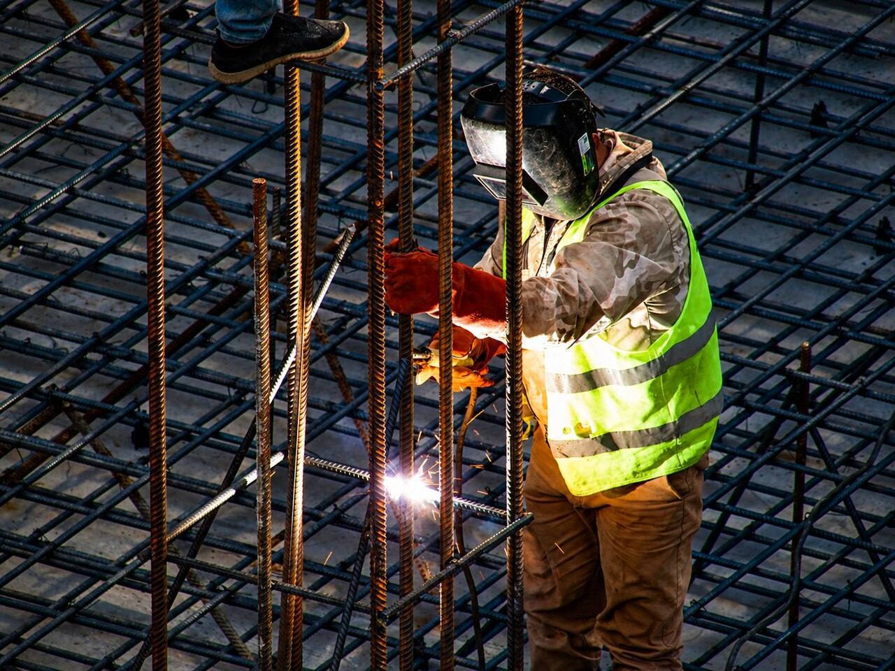 Arbeiter schweißt an einer Bewehrung