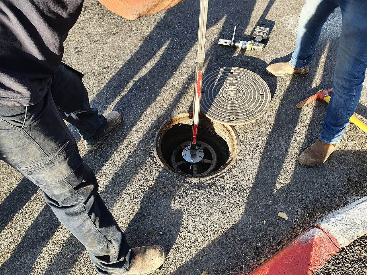 Arbeiten an einem Wasserleitungsschacht auf der Straße