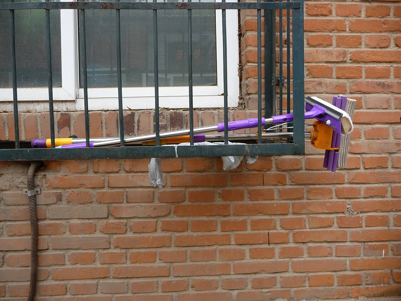 Wischmopp an einem Fenstergitter