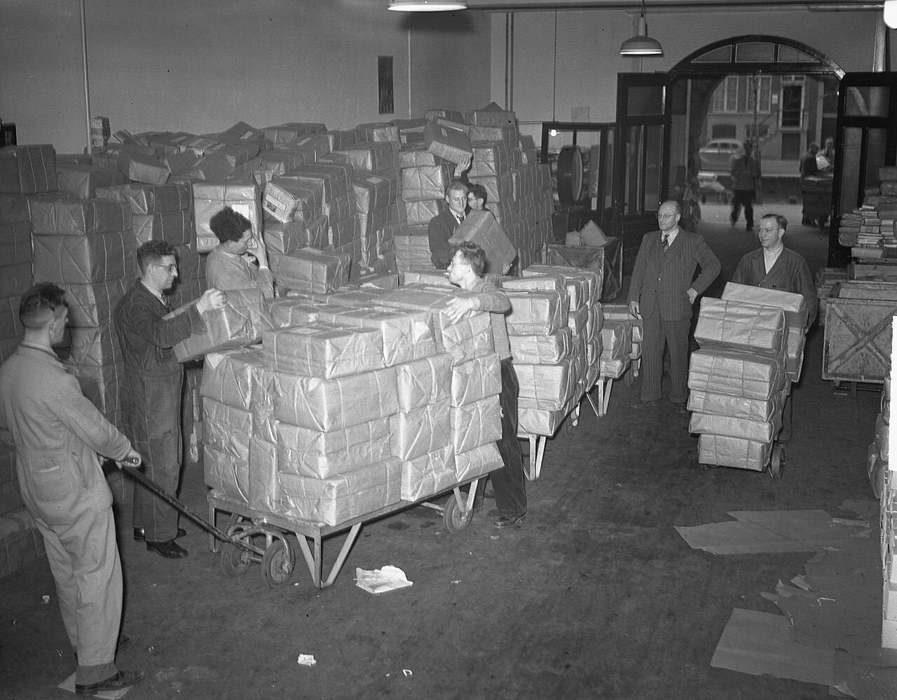 Historisches Paketlager mit Arbeitern und Paketstapeln