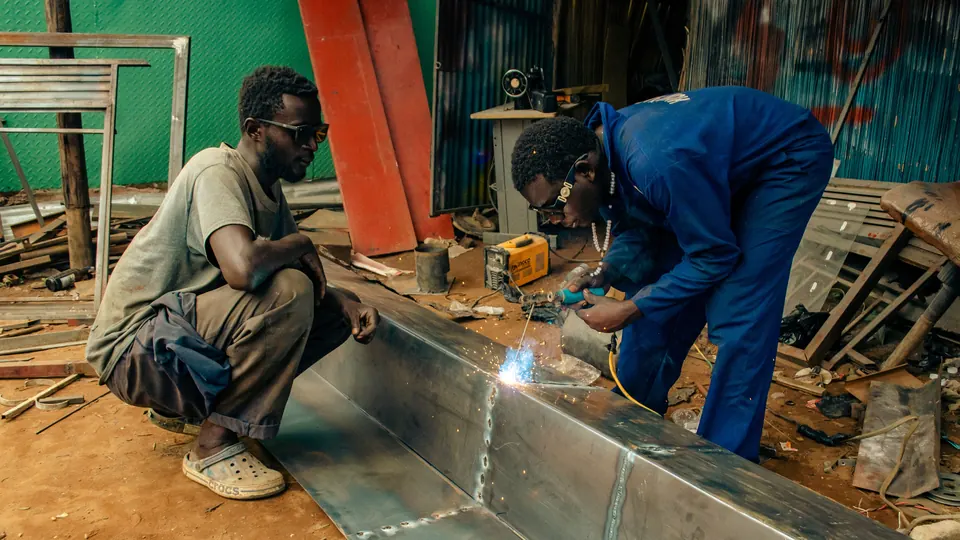 Zwei Handwerker schweissen in einer Werkstatt Metallteile