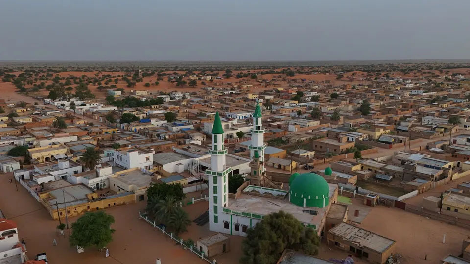 Luftaufnahme einer Moschee mit grünen Kuppeln in einer Ortschaft in Mauretanien.