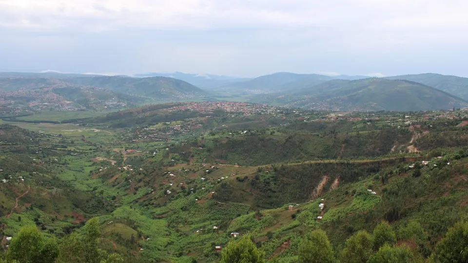 Grüne Hügellandschaft mit verstreuten Häusern in Ruanda.