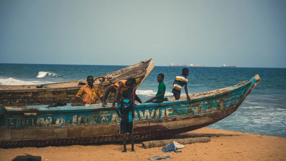 Holzboote und Fischer am Sandstrand in Togo.