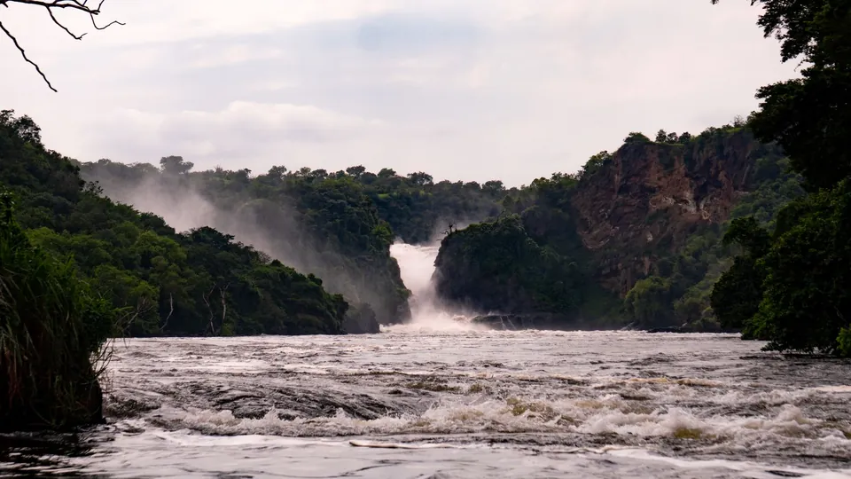 Murchison Falls im Nationalpark in Uganda mit schäumendem Fluss im Vordergrund.